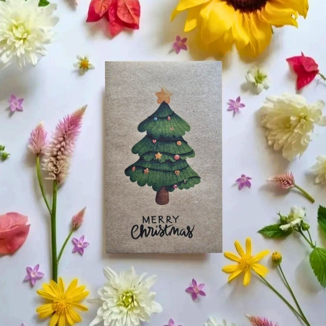 Recycled Christmas seed card with illustrated green Christmas tree and “Merry Christmas” text, plantable wildflower seed paper.
