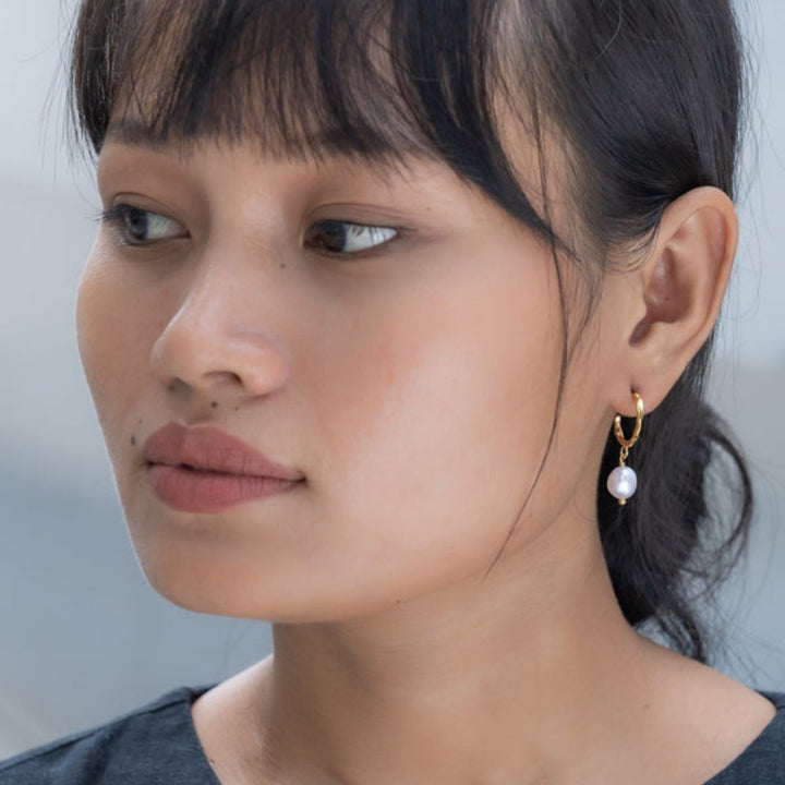 Milk & Honey Hoop Earrings feature a freshwater pearl on 18K gold-plated stainless steel hoops. Profits support women from trafficking through Eden’s programs.