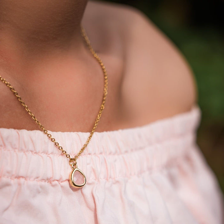 Eden Desert Sunrise Necklace has a pink or teal glass stone on an 18K gold-plated chain. Profits support women rescued from trafficking through Eden’s programs.
