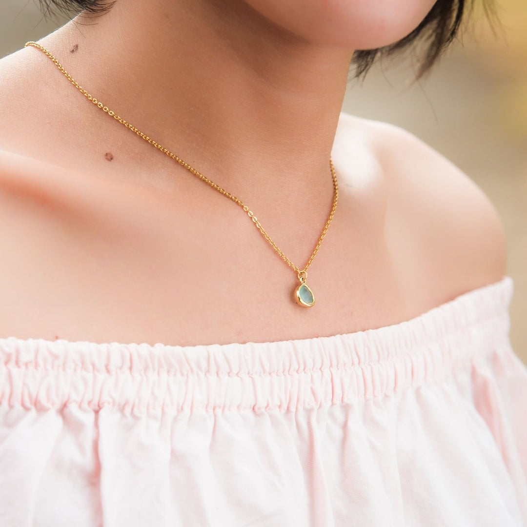 Eden Desert Sunrise Necklace has a pink or teal glass stone on an 18K gold-plated chain. Profits support women rescued from trafficking through Eden’s programs.