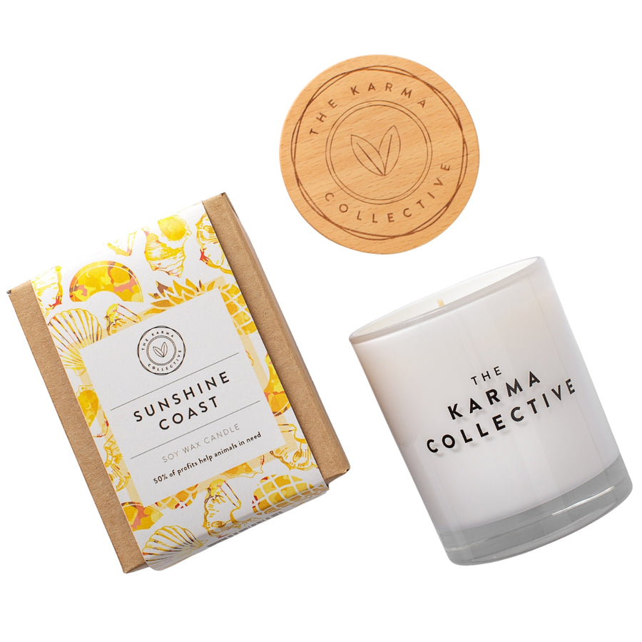 The Karma Collective Sunshine Coast Soy Wax Candle in an elegant white glass jar with a wooden lid. A warm, sweet scent with ethically sourced ingredients. 50% of each Karma Collective premium soy candle's profits are donated to World Animal Protection Australia, making it a perfect eco-friendly gift.