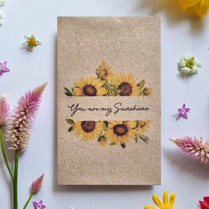 You Are My Sunshine sunflower seed greeting card surrounded by flowers, plantable sunflower seed gift card